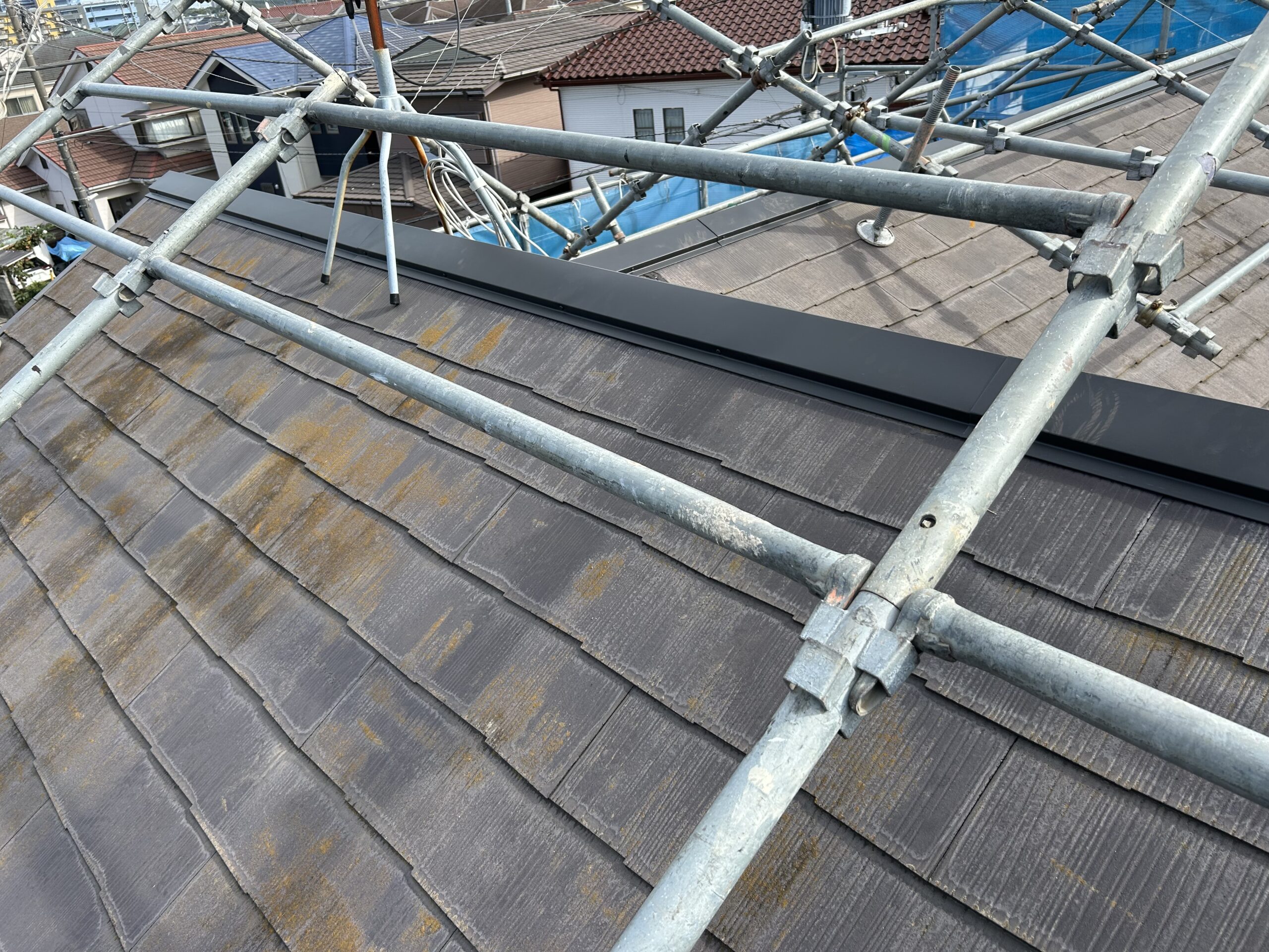 屋根にペンキを塗っている画像